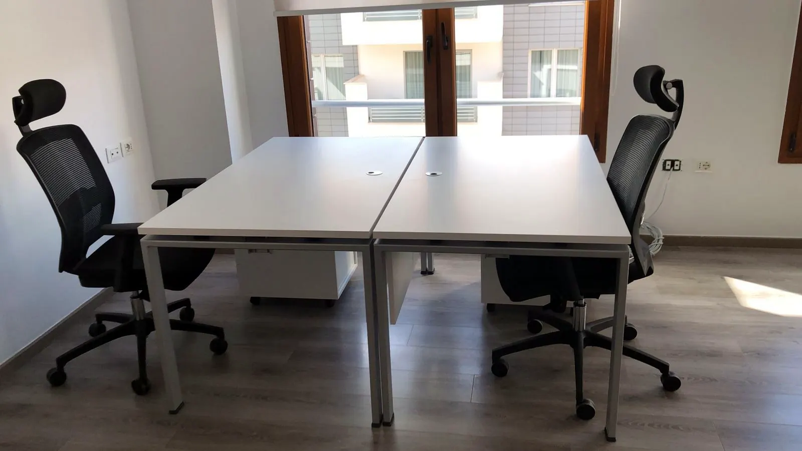 Dy tavolina pune të bardha me karrige ergonomike