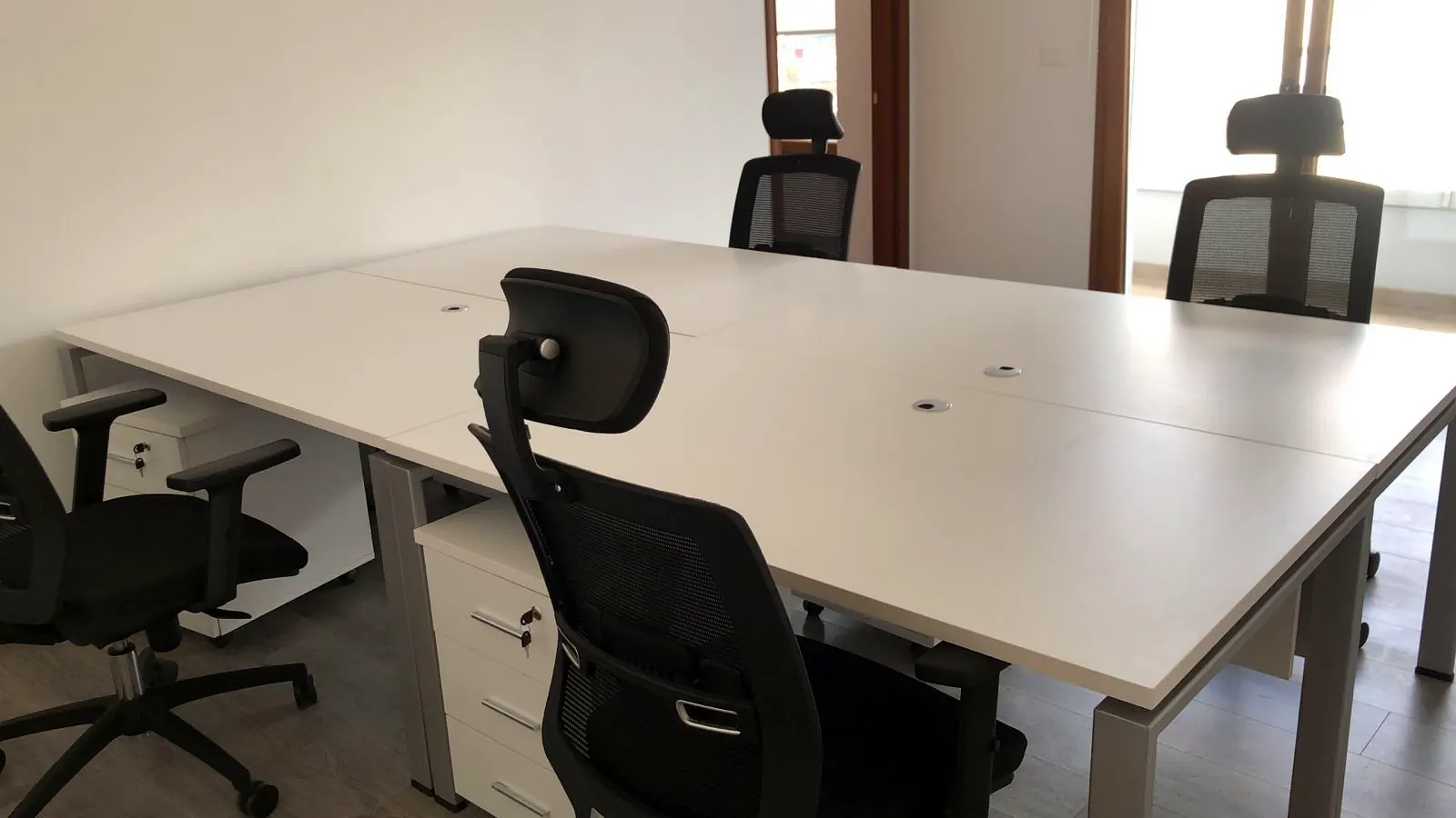Karrige ergonomike me rrjetë dhe mbështetëse koke në një zyrë pune